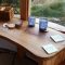 Elm desk facing out a window warm swirling grain patterns